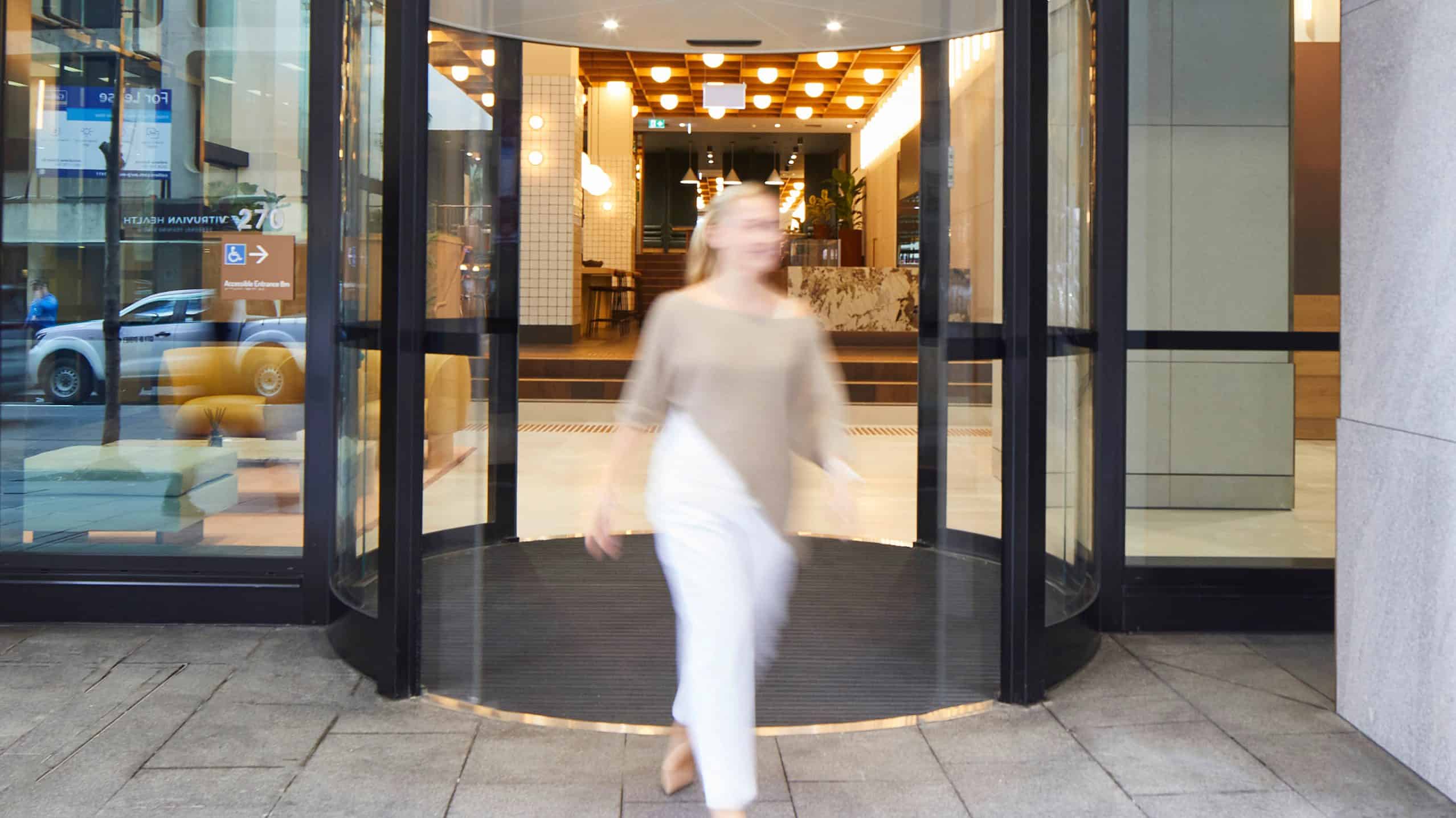 Girl walking out of revolving doors of 270 Pitt St